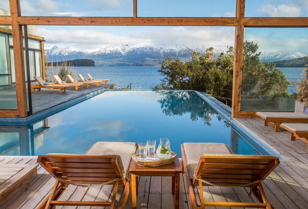 Infinity pool with a wooden deck at Correntoso Lake & River Hotel