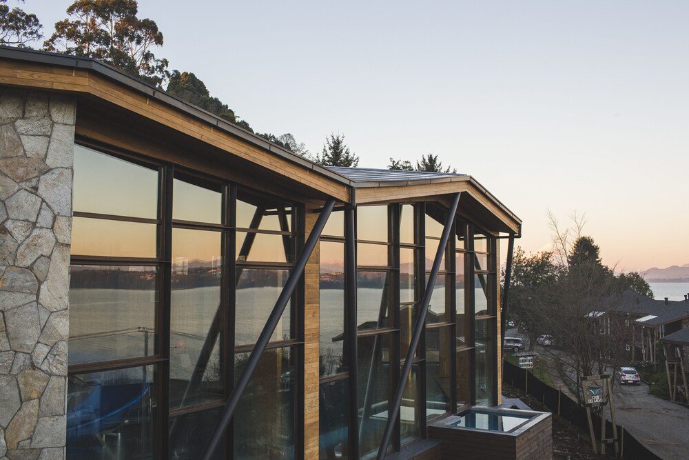 Modern hotel building with large glass windows by the lake